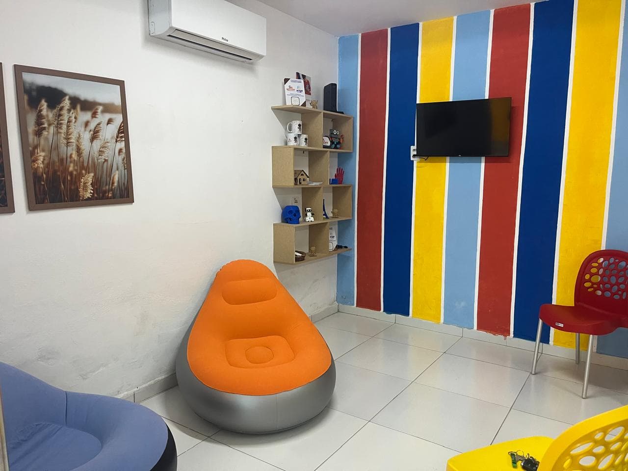 Espaço de convivência do Clube de Robótica, com estante de troféus e mascotes