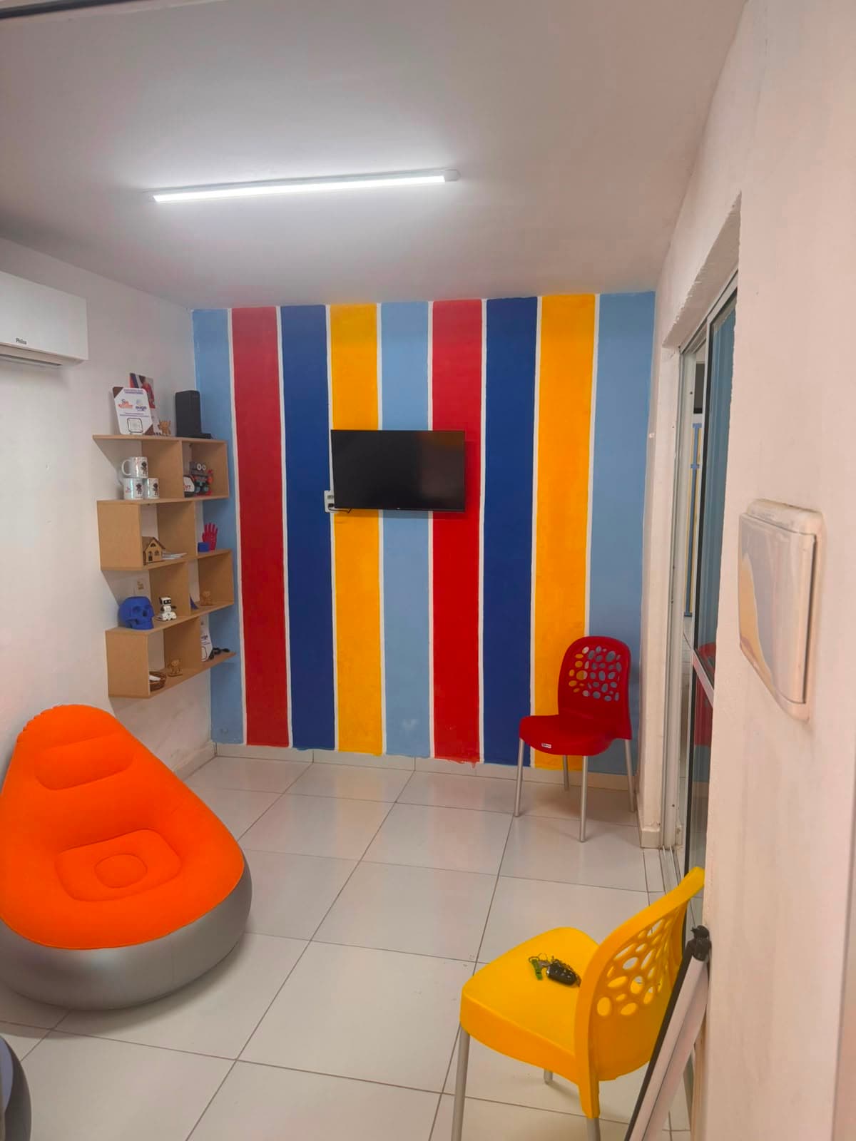 Sala de aula do Clube de Robótica com parede colorida e TV
