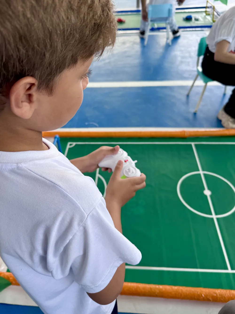Aluno controlando o robô durante o futebol de robôs
