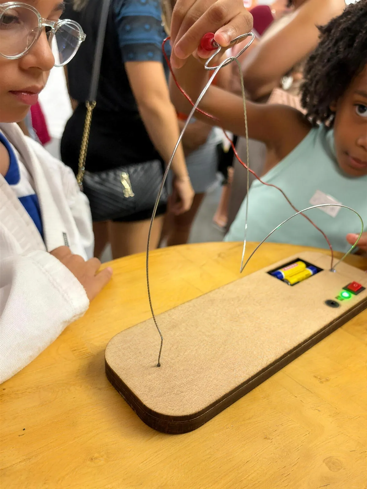 Alunos testando o labirinto elétrico que construíram