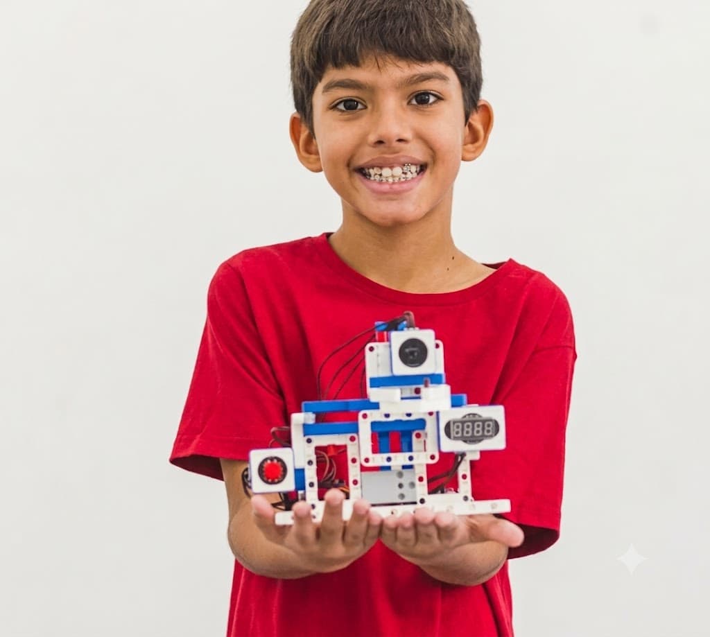 João, aluno da Student Maker, sorrindo com o robô que montou